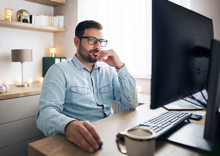 man working in home office at computer