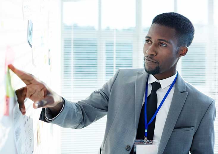 Criminal Justice student pointing at information on white board