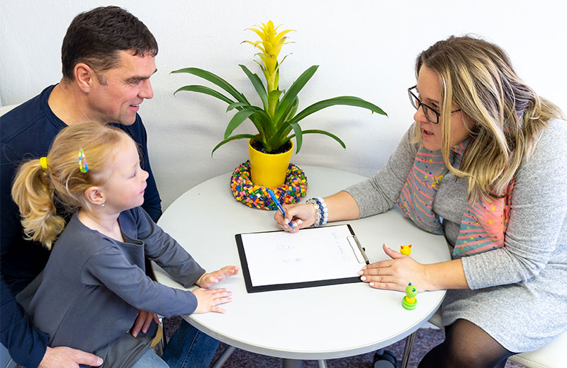 healthcare administrator working with parent and child on intake forms